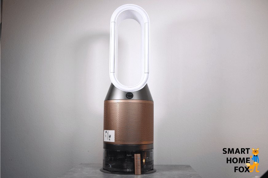 Der Dyson Purifier Humidify+Cool Formaldehyde PH04 Luftreiniger, Luftbefeuchter und Ventilator steht auf einem Tisch vor einer weißen Wand